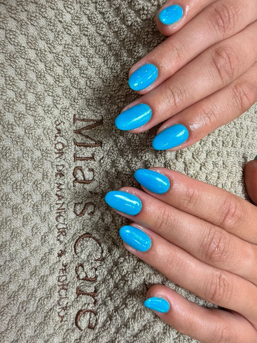 Manicura semipermanente azul con brillo, forma almendra